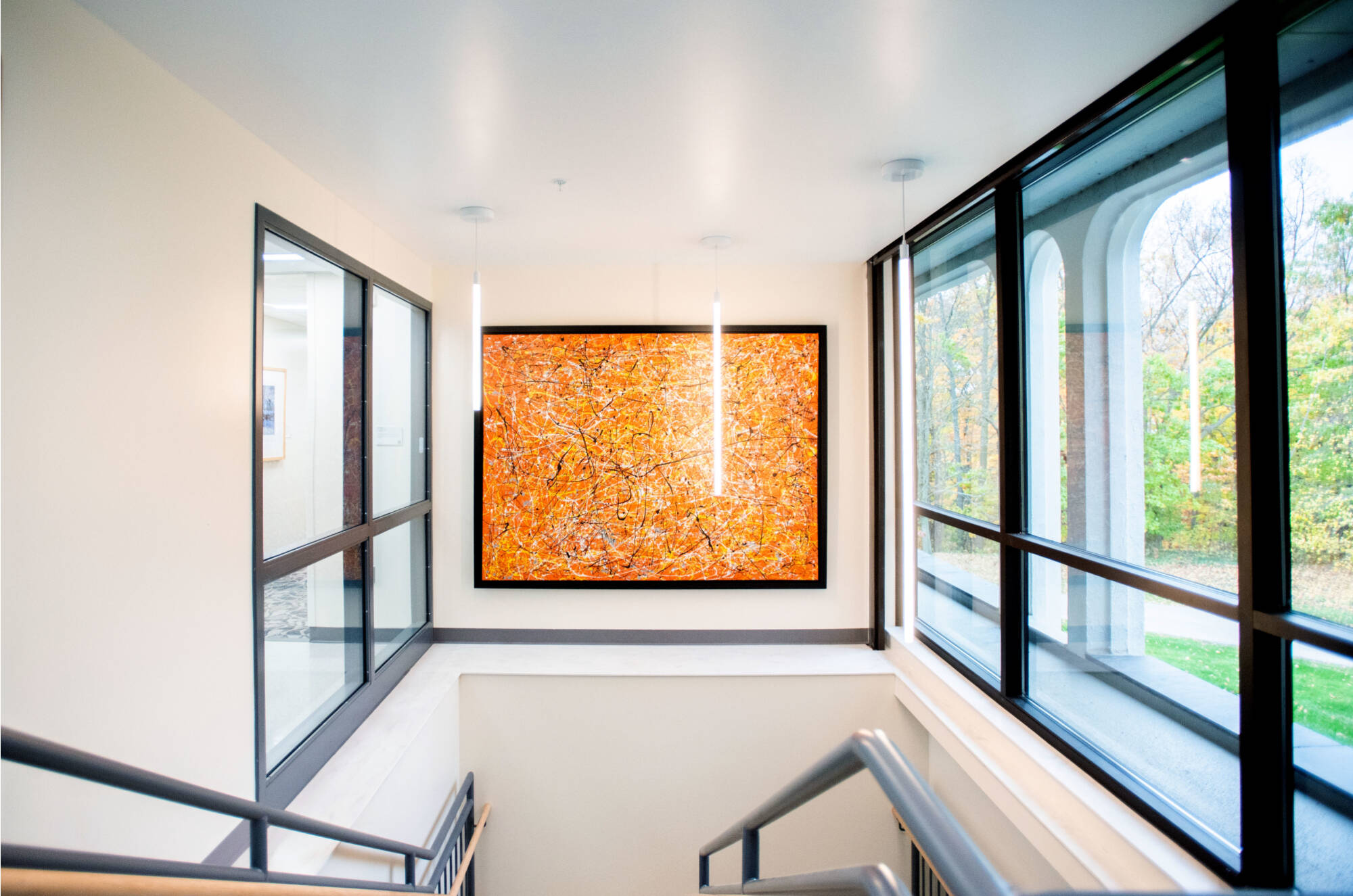 Interior stairwell of Lake Huron Hall with a bright orange abstract painting.